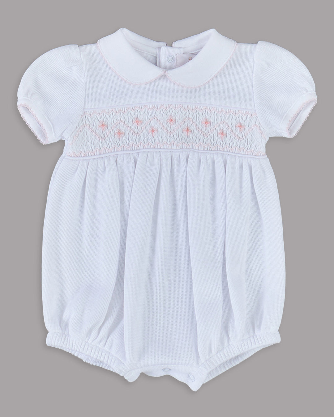 Romper branco para bebê com bordados rosas, desenho delicado e encantador para qualquer ocasião especial.