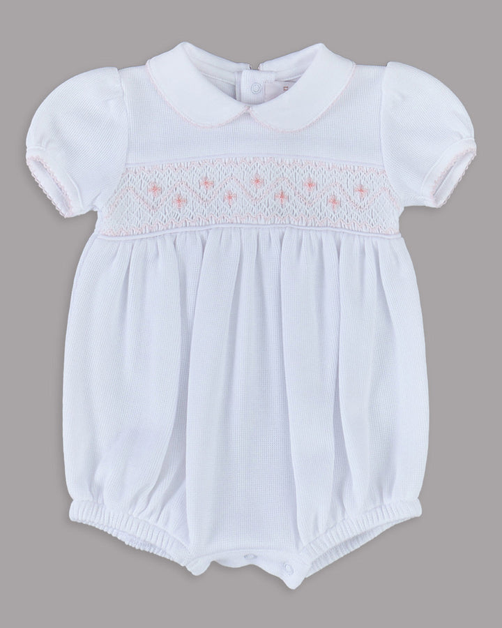 Romper branco para bebê com bordados rosas, desenho delicado e encantador para qualquer ocasião especial.