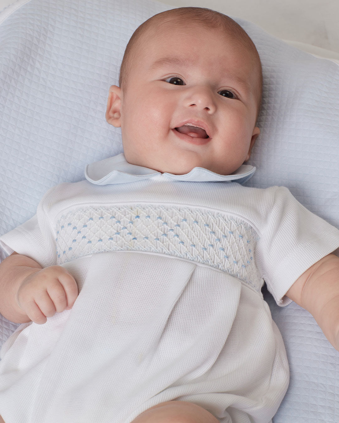 Romper branco com detalhes celestes, perfeito para adicionar estilo e confort para o guarda-roupa do bebê.