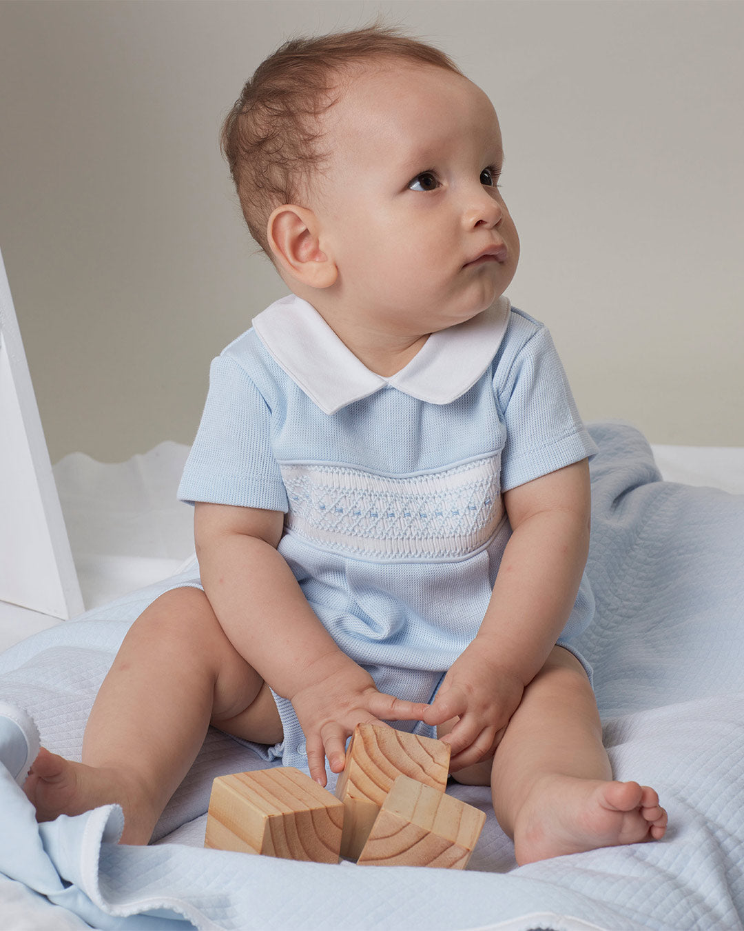Macacão curto Alessi para bebês na cor celeste com bordado smocking inglês 
